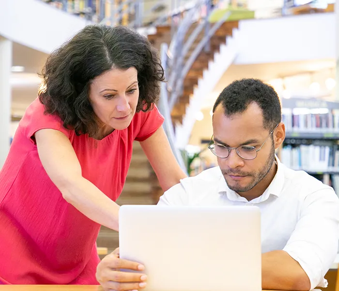Psicóloga y profesional afin reunidos revisando investigación en un computador